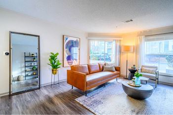 A living room with a brown sofa and a grey coffee table.
